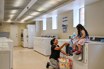 A woman and a child are in a laundromat
